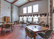 Thumbnail 2 of 13 - A room with wooden floors and tables with chairs.