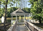 Thumbnail 23 of 25 - A gazebo sits on a wooden pier over a body of water.