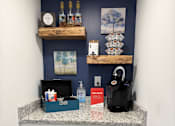Thumbnail 22 of 25 - A kitchen with a wine cooler and a black kettle on the counter.