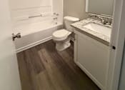 Thumbnail 9 of 25 - A small bathroom with a toilet, sink, and bathtub.