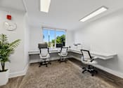 Thumbnail 18 of 22 - Business center with desks and natural light at Wilton Tower pet-friendly apartments in Wilton Manors, FL.