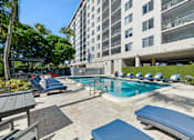 Thumbnail 14 of 22 - Pool deck with loungers at Wilton Tower apartments near Fort Lauderdale in Wilton Manors, FL.