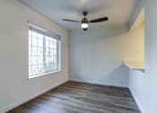 Thumbnail 5 of 35 - Apartments for Rent in Everett, Washington - Woodbrook - Dining Room with Wood-Style Flooring, Ceiling Fan, and Large Window.