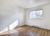 Thumbnail 8 of 35 - Apartments for Rent in Everett Washington - Woodbrook - Empty Bedroom with Wood-Style Flooring and Window