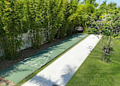 Thumbnail 4 of 23 - landscaped walkway and shuffle board at Woodlake Villas apartments in Orlando Florida
