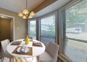 Thumbnail 3 of 17 - a dining room with a table and chairs and large windows