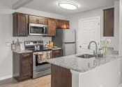 Thumbnail 12 of 30 - apartment kitchen in Holly Michigan with refrigerator, oven, and microwave