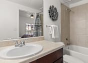 Thumbnail 16 of 30 - A bathroom with a white sink and a white tub.