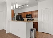 Thumbnail 7 of 30 - A kitchen with a white counter and brown cabinets.