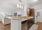 Thumbnail 6 of 30 - A modern kitchen with a marble countertop and dark wood cabinets.