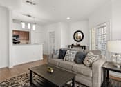 Thumbnail 1 of 30 - A living room with a grey couch and a coffee table.