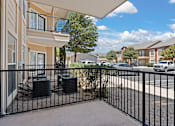 Thumbnail 18 of 30 - A black metal fence surrounds a patio with a table and chairs.