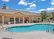 Thumbnail 20 of 30 - A pool area with a building in the background.