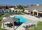 Thumbnail 24 of 32 - A pool with a table and chairs is surrounded by a fence.