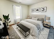 Thumbnail 4 of 20 - A bedroom with a large bed, a bench, and three framed pictures on the wall.