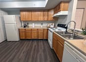 Thumbnail 7 of 20 - a kitchen with white appliances and wooden cabinets