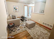 Thumbnail 1 of 20 - A living room with a couch, chair, and rug.