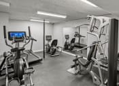 Thumbnail 22 of 27 - a gym with various machines and weights in a room