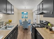 Thumbnail 5 of 27 - a kitchen with black appliances and a table with chairs
