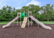 Thumbnail 26 of 27 - a playground with slides and a rock wall