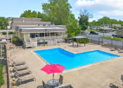 Thumbnail 25 of 27 - a swimming pool with an umbrella in front of a house