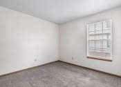 Thumbnail 10 of 28 - a bedroom with white walls and a window