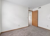 Thumbnail 12 of 28 - a carpeted bedroom with white walls and a wooden door