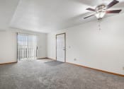 Thumbnail 7 of 28 - apartment living room with a ceiling fan and a door to a balcony