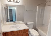 Thumbnail 12 of 28 - A white sink with a wooden cabinet below it.