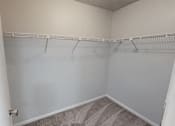 Thumbnail 17 of 28 - A room with a white wall and a grey carpet.