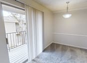 Thumbnail 3 of 28 - A room with a sliding glass door and a hanging light fixture.