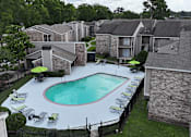 Thumbnail 27 of 28 - A swimming pool surrounded by lounge chairs and umbrellas in a residential area.
