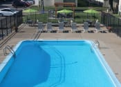 Thumbnail 5 of 13 - a large pool with chairs and umbrellas with a grilling area in the background