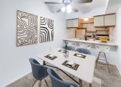 Thumbnail 1 of 19 - a dining area with a table and chairs and a kitchen in the background