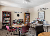 Thumbnail 2 of 9 - A room with a table, chairs, and bookshelves.