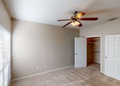 Thumbnail 12 of 24 - a bedroom with a ceiling fan and closet