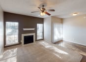 Thumbnail 11 of 24 - a living room with a fireplace and a ceiling fan