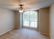 Thumbnail 7 of 24 - a bedroom with a large window and a ceiling fan