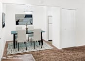 Thumbnail 9 of 32 - A dining room with a table and chairs.
