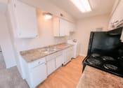 Thumbnail 2 of 27 - a kitchen with cabinets and a stove and a sink