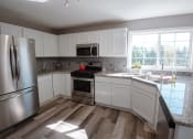 Thumbnail 15 of 32 - a kitchen with white cabinets and stainless steel appliances