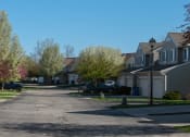 Thumbnail 29 of 32 - a street in a neighborhood with houses and a stop sign