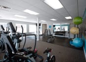 Thumbnail 18 of 32 - a gym with weights and other exercise equipment in a workspace
