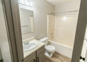 Thumbnail 5 of 23 - A bathroom with a toilet, sink, and bathtub.