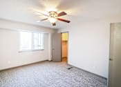 Thumbnail 3 of 23 - A room with a ceiling fan and a door.
