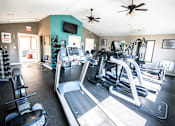Thumbnail 9 of 23 - A gym with treadmills, exercise bikes, and other equipment.