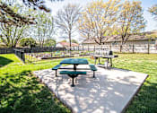 Thumbnail 14 of 23 - A green picnic table and bench are in a sunny park.
