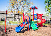 Thumbnail 10 of 23 - A playground with a red and blue slide and a yellow arch.
