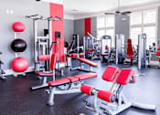 Thumbnail 9 of 11 - Apartment community gym with a variety of equipment including weights and benches.