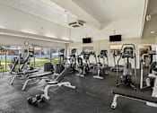 Thumbnail 11 of 22 - A gym with a variety of equipment including treadmills, weights, and exercise machines.